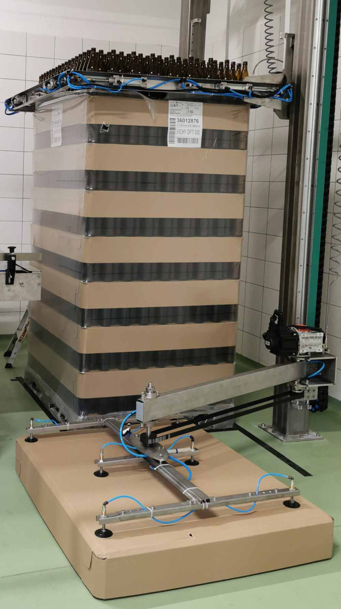 Robot depaletyzujący przekazujący butelki lub worki z palety na transporter magazynowy